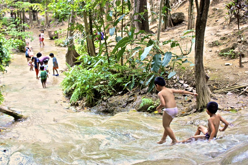 kids playing in the runoff of the Sai Yok Noi waterfall