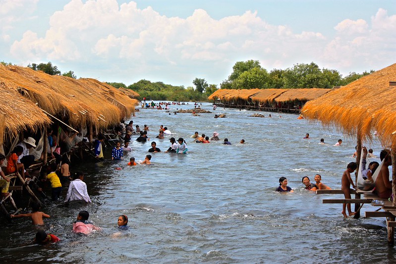Just outside of Kratie, locals enjoy these thatched roof shacks on the river as they get a massage from rapids on the Mekong Just outside of Kratie, locals enjoy these thatched roof shacks on the river as they get a massage from rapids on the Mekong