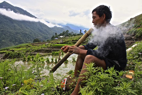a Hmong man demonstrates his pipe