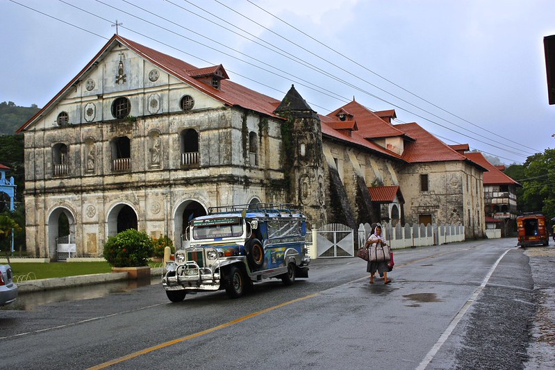 A Jeepney drops off passengers in front of an old building A Jeepney drops off passengers in front of an old building
