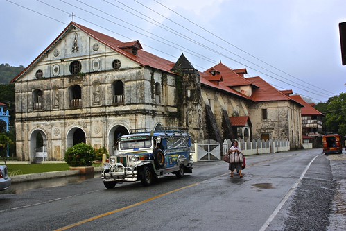 A Jeepney drops off passengers in front of an old building